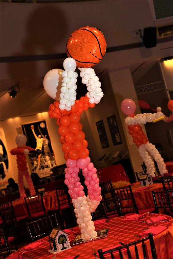 basketball player balloon sculpture centerpiece on tables with basketball balloons