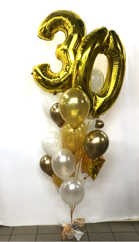 A bouquet of colorful balloons including large gold number balloons and smaller latex balloons, tied together at the bottom.