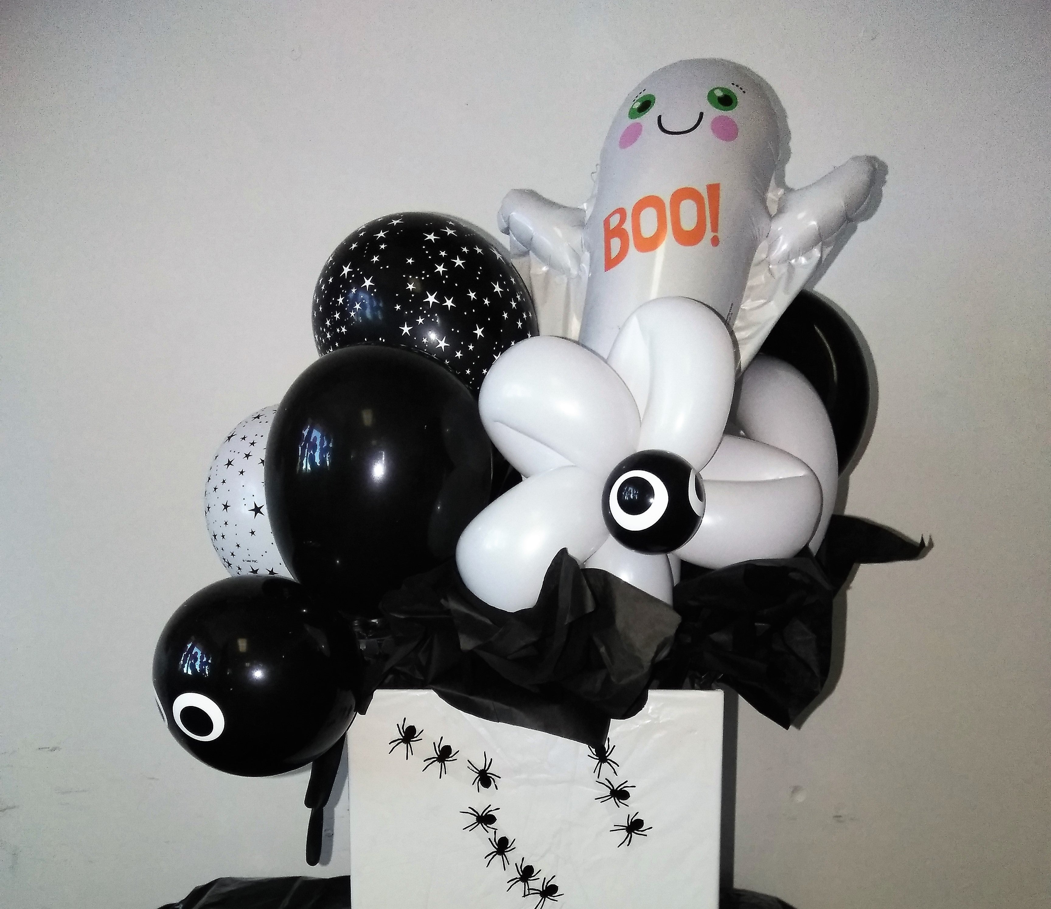 box decorated with spider stickers filled with Halloween themed balloons-ghost balloons and eyeball balloons