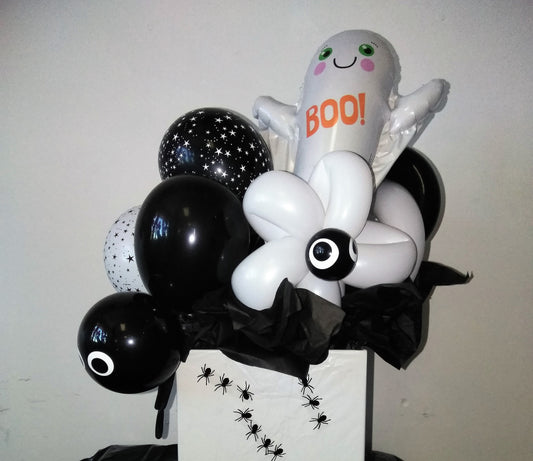 box decorated with spider stickers filled with Halloween themed balloons-ghost balloons and eyeball balloons