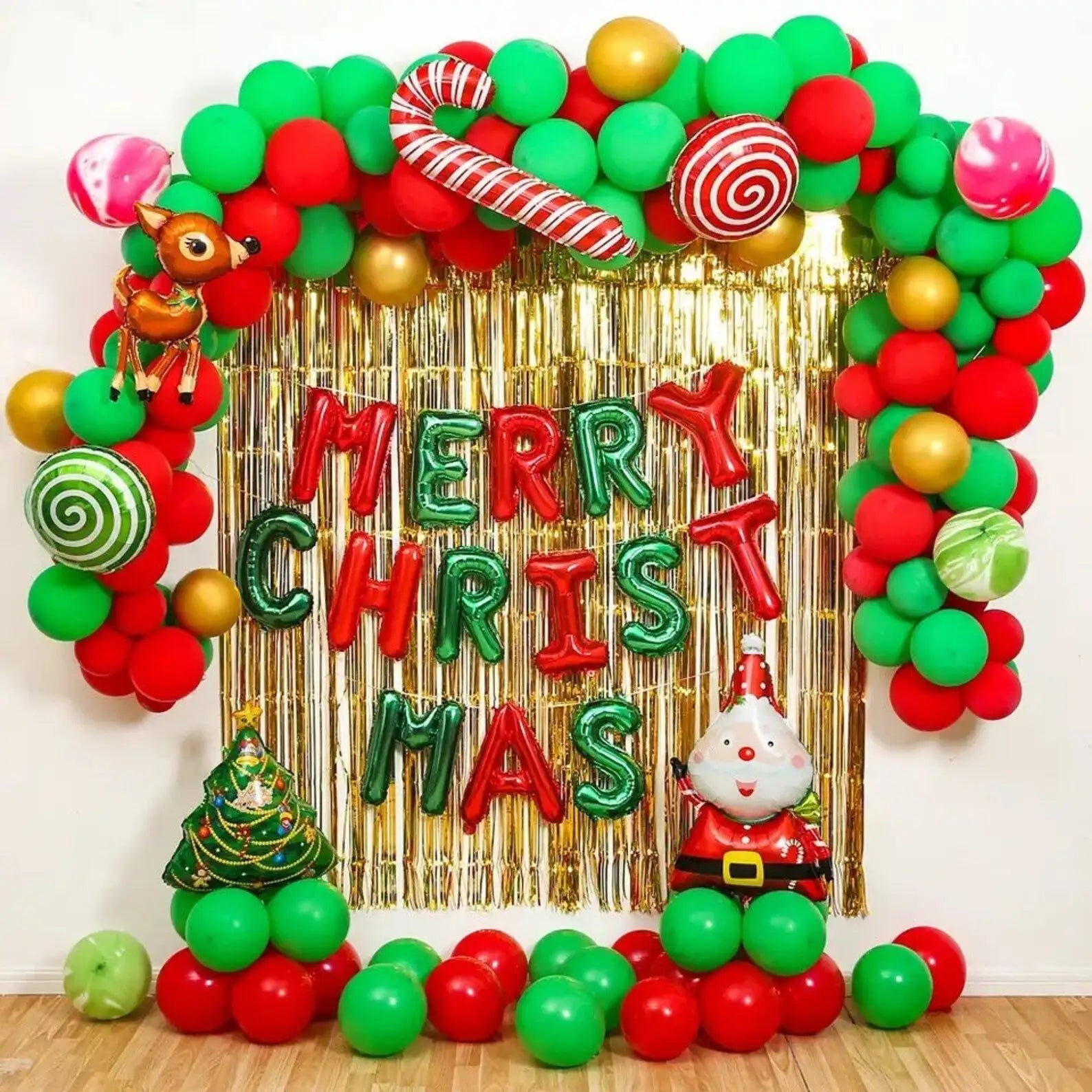 A festive christmas balloon arch adorned with red, green, and gold balloons shaped like candy canes and lollipops.