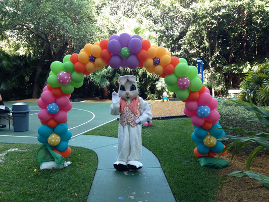 a balloon arch made with colorful flowers in spring colors