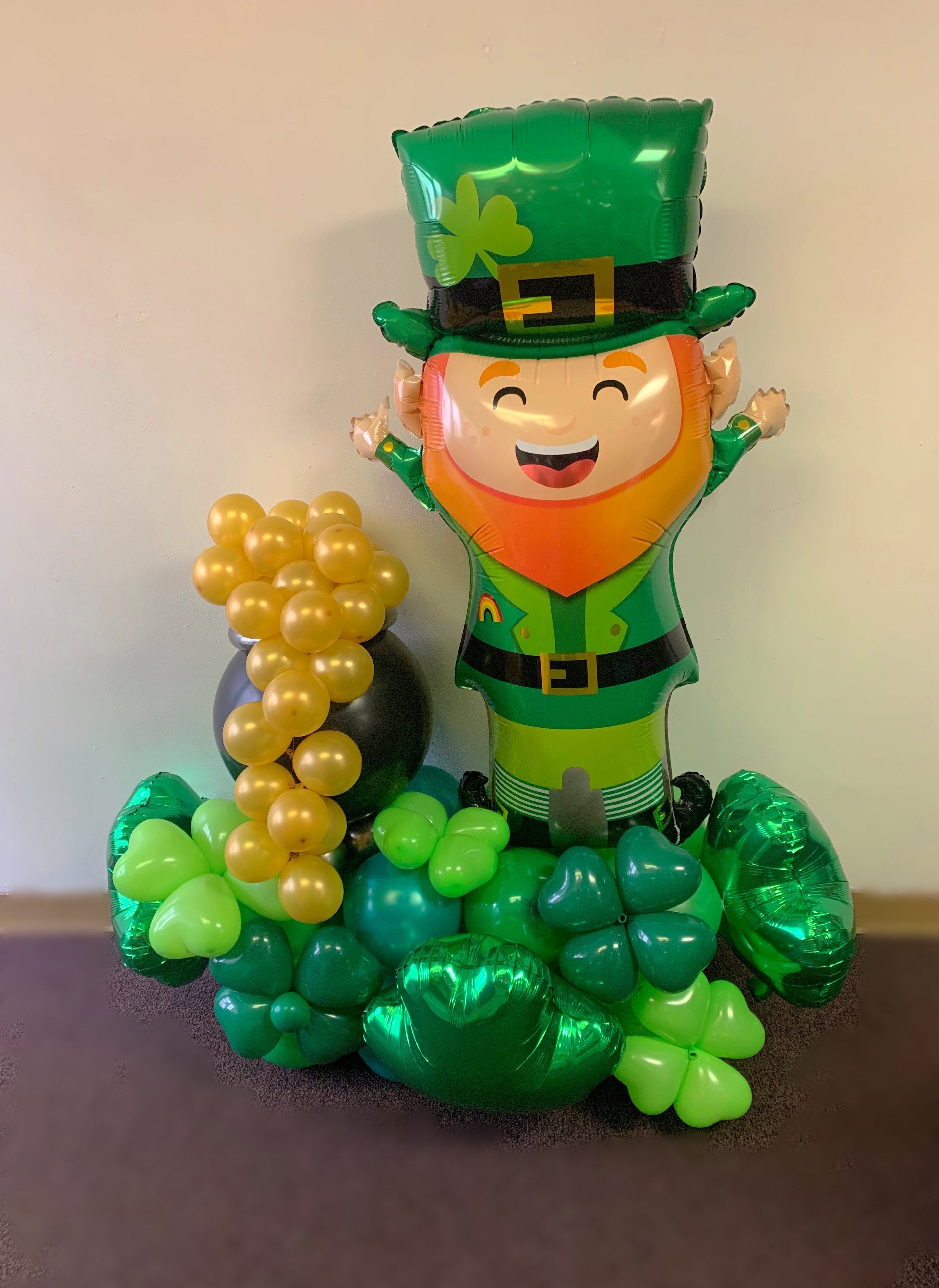 The Lucky Leprechaun  balloon is standing on a bed of green balloons enhanced with sculptured four leaf clovers and a black pot of gold.  Good  St. Patrick's day Prop.