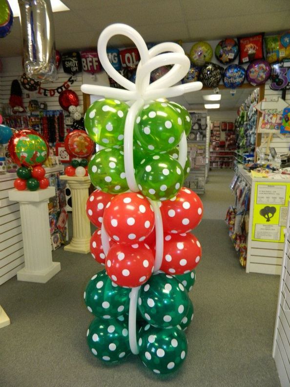 balloon wrapped Christmas presents stacked to make a balloon column with balloon bow on top