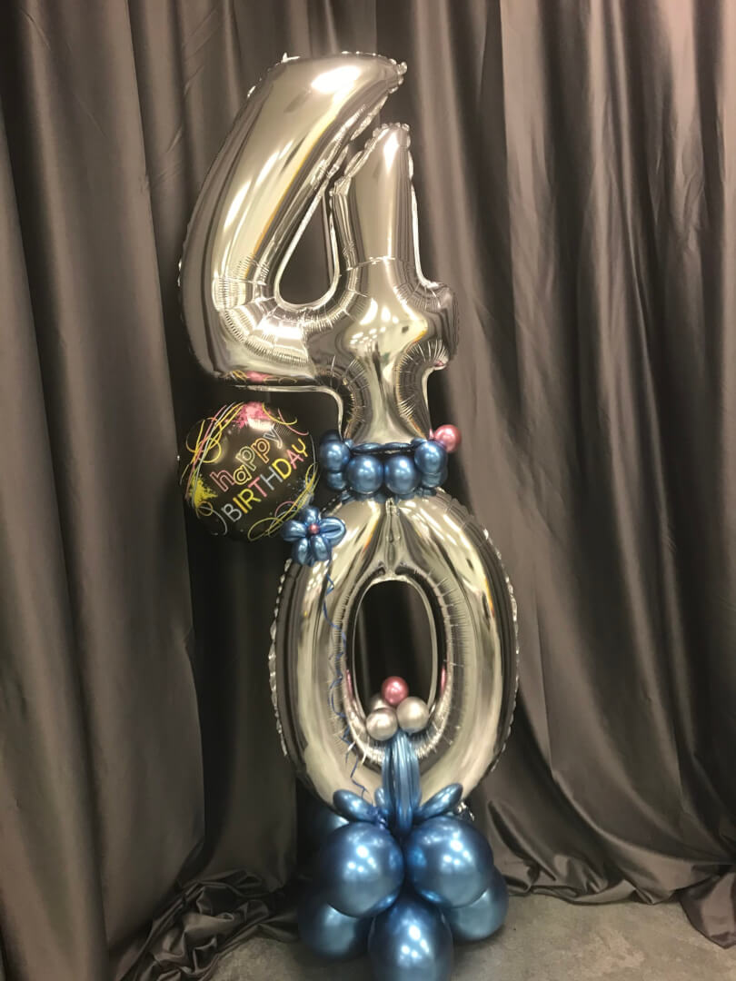 large silver number balloons in an arrangement with foil happy birthday balloon and chrome blue balloons added