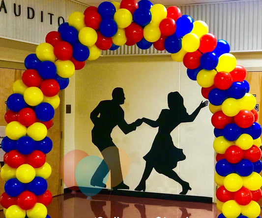 classic balloon arch with blocked colors of red, yellow and blue, silhouette of dancing couple