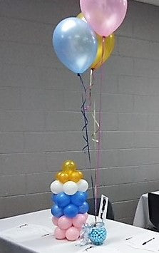 Baby Bottle balloon centerpiece pink, blue white and gold with 3 helium party balloons attached to a balloon bottle sculpture made of white blue, pink and gold balloons balloons added.