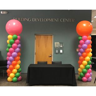 yellow, green ,rose, lavender and orange Classic balloon columns with 36 inch balloon toppers flanking a 6 foot table
